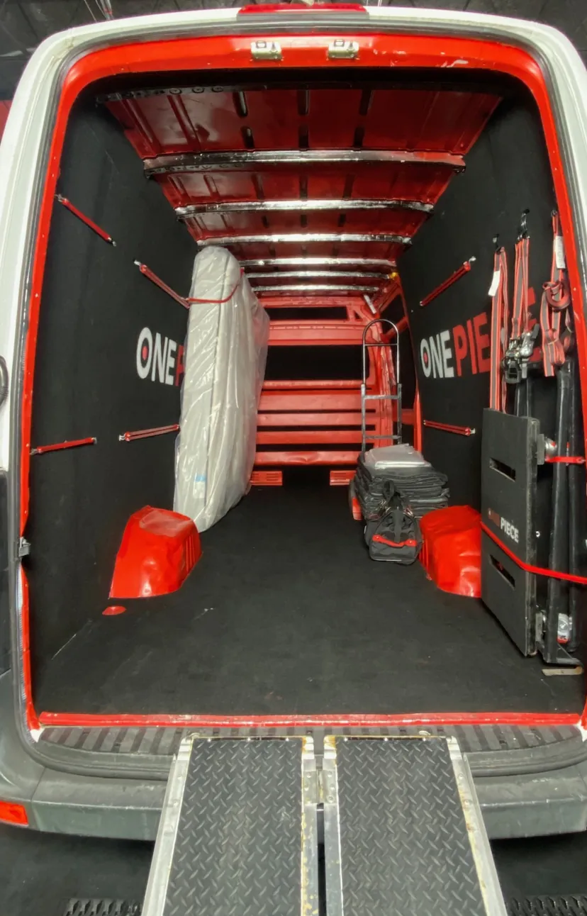 Inside a One Piece Delivery Sprinter van with ramp, straps, and dollies